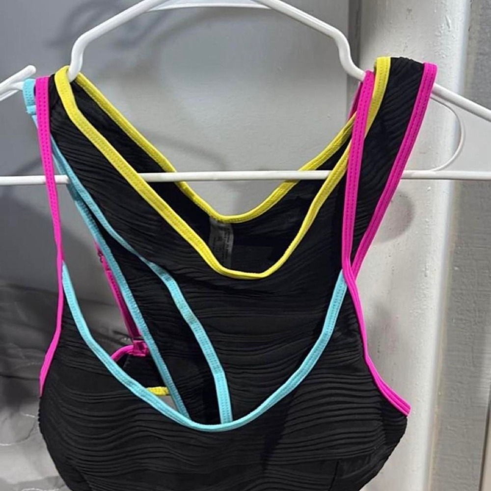 Black sports bra with yellow, pink, and light blue trim